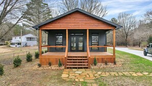 A wooden cabin with a porch, a stone pathway, and a vehicle parked nearby. - NEW 6 Bedrooms - Two houses and a pavillion on Chickamauga Lake with new dock
 (Decatur)