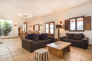 Un salón amplio con un conjunto de sofás, una mesa de centro y un comedor con sillas y una mesa.