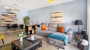 Een moderne woonkamer met een bank, salontafel en een eethoek.
