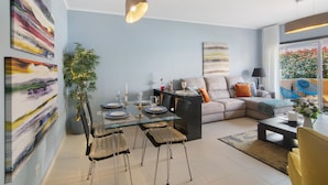 Een moderne woonkamer met een eettafel, bank en een groot raam met uitzicht.