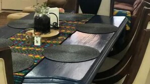 Uma área de refeições com uma mesa comprida, cadeiras e um ventilador de teto.