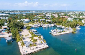A marina with boats, a beach area, and surrounding buildings.
