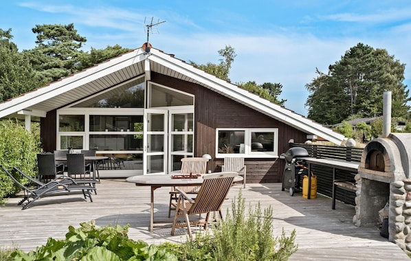 Enjoy meals and social gatherings on the outdoor deck with a dining set and a stone oven.