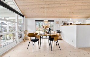 Enjoy meals in this dining area with a round table and chairs, surrounded by a view of the outdoors.