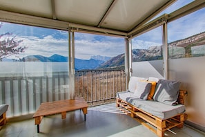 A balcony with a sofa and a table, offering a mountain view. - Holiday Home 'Gîte Ludomi' with Mountain View, Balcony and Wi-Fi (VERCHENY)