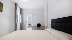 A hotel room with a bed, a desk, and a chair. - Apartment "Don Juan Manuel" with Shared Pool & Wi-Fi (Torremolinos)