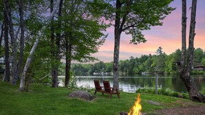 A serene lakeside setting with a fire pit and two chairs facing the water. - Lakefront Cabin/ 314`  Shoreline (Stoddard)