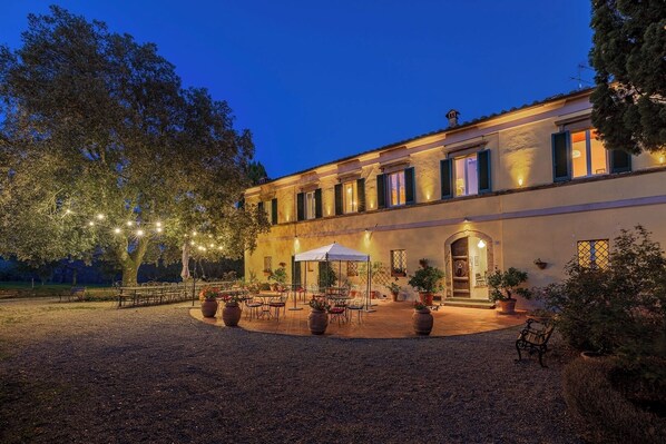 A building with a courtyard, outdoor seating, and potted plants.