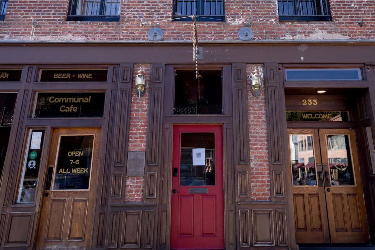 A brick building with a red door, labeled "233" and "WELCOME".