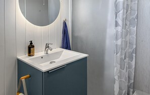 A bathroom with a white sink, a mirror, and a towel hanging on a rack.