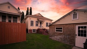 Un quartier résidentiel comprenant deux maisons, une clôture en bois et une pelouse bien entretenue.