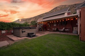 A backyard with a hot tub, outdoor seating, and a mountain backdrop. - Copper Queen's Retreat (Bisbee)