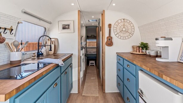 A compact kitchen with a central island, a coffee machine, and a guitar on the wall. - NEW! Cozy, Desert Dream Airstream with Firepit (Tombstone)