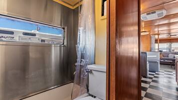 Una cocina compacta con refrigerador, lavamanos y retrete.