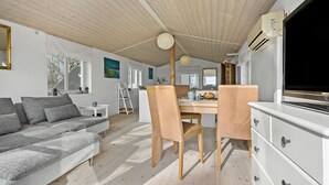 A modern living room with a sofa, chairs, a dining table, and a TV. - 1 bedroom awesome apartment in Grevinge (Grevinge)