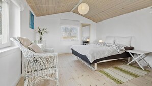 A bedroom with a bed, a wicker chair, a nightstand, a mirror, and a window. - 1 bedroom awesome apartment in Grevinge (Grevinge)