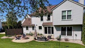A two-story house with a patio area, a fire pit, and outdoor seating. - Beautiful Waukesha Home (Waukesha)