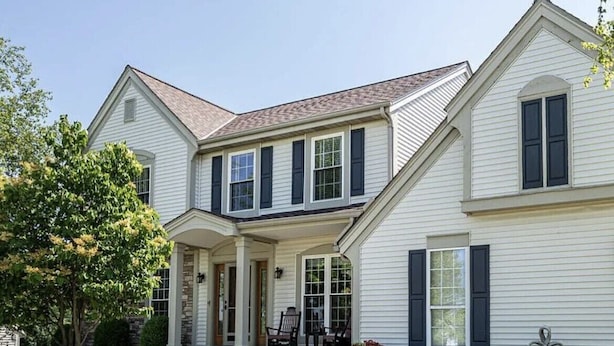 A two-story house with a front porch, stone foundation, and a well-maintained lawn. - Beautiful Waukesha Home (Waukesha)