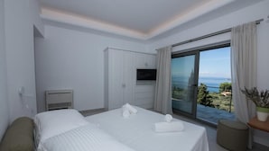 Ein modernes Hotelzimmer mit zwei Betten, einem Fernseher und einem Balkon mit Meerblick.