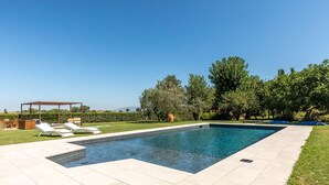 A rectangular swimming pool with a pergola and lounge chairs on one side. - Cozy home in Spoleto with WiFi (Spoleto)
