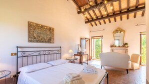 A bedroom with a bed, a chair, a vanity with a mirror, and a map on the wall. - Cozy home in Spoleto with WiFi (Spoleto)