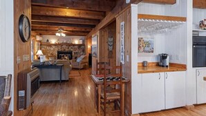 A cozy kitchen with wooden cabinets, a dining table, and a fireplace.