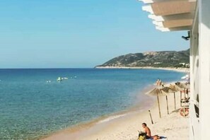 Relax on the beach with a clear view of the sea and a shaded area nearby.
