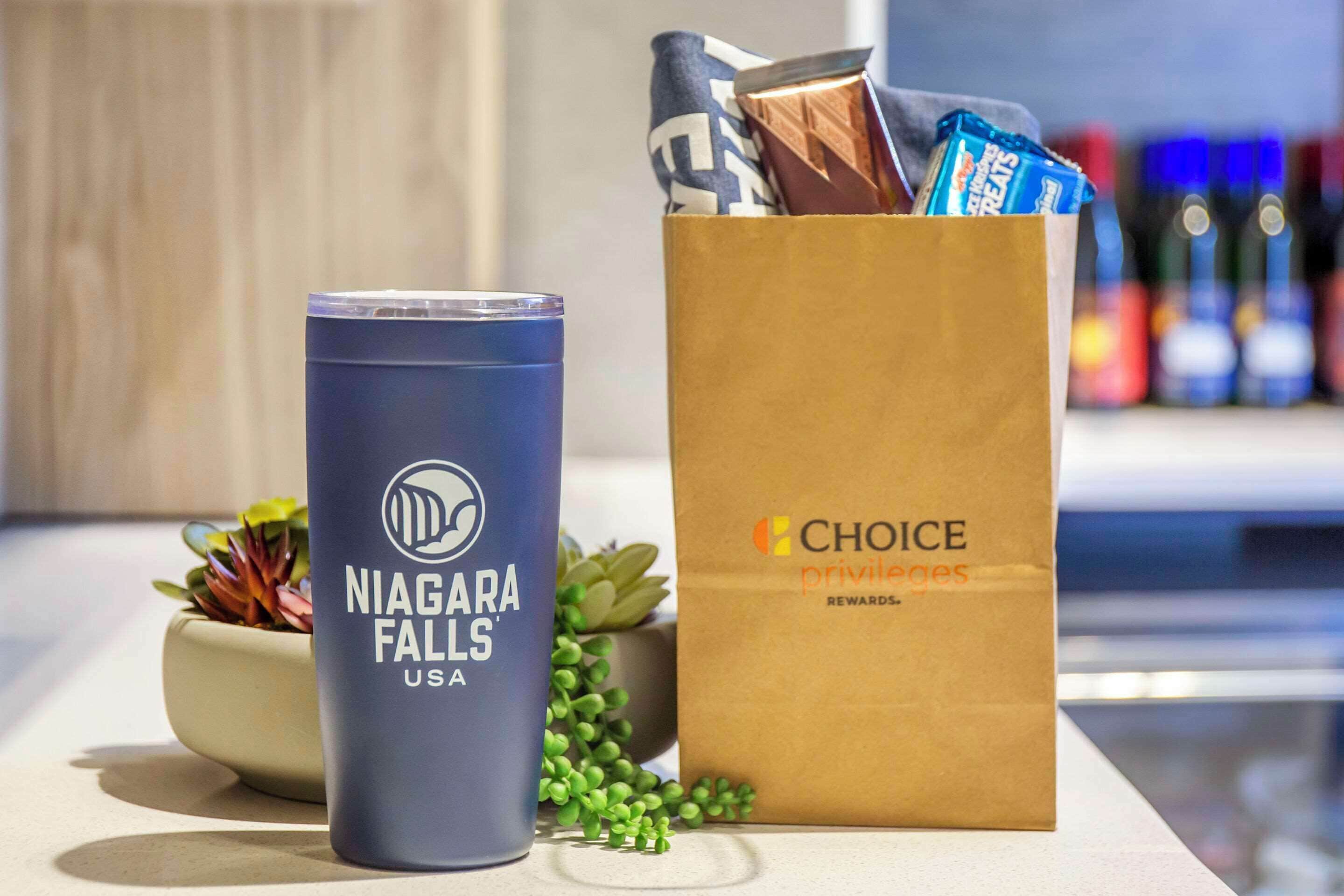A blue tumbler labeled "Niagara Falls USA" and a brown paper bag with "CHOICE privileges" text.
