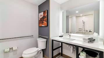 Un baño moderno con inodoro, lavamanos y ducha.