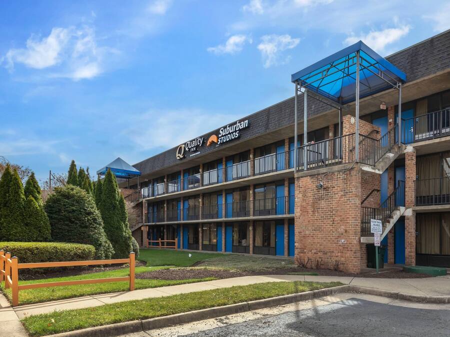 A multi-story building with a sign for 'Quality Inn Suburban Studios'.