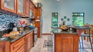 Una cocina amplia con armarios de madera, encimera de granito y una isla central.