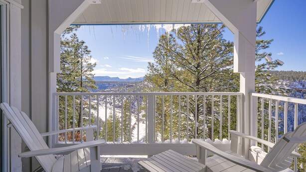 A covered porch with white railings and two white Adirondack chairs. - Pagosa Springs Family Retreat w/ Game Room & Views (Pagosa Springs)