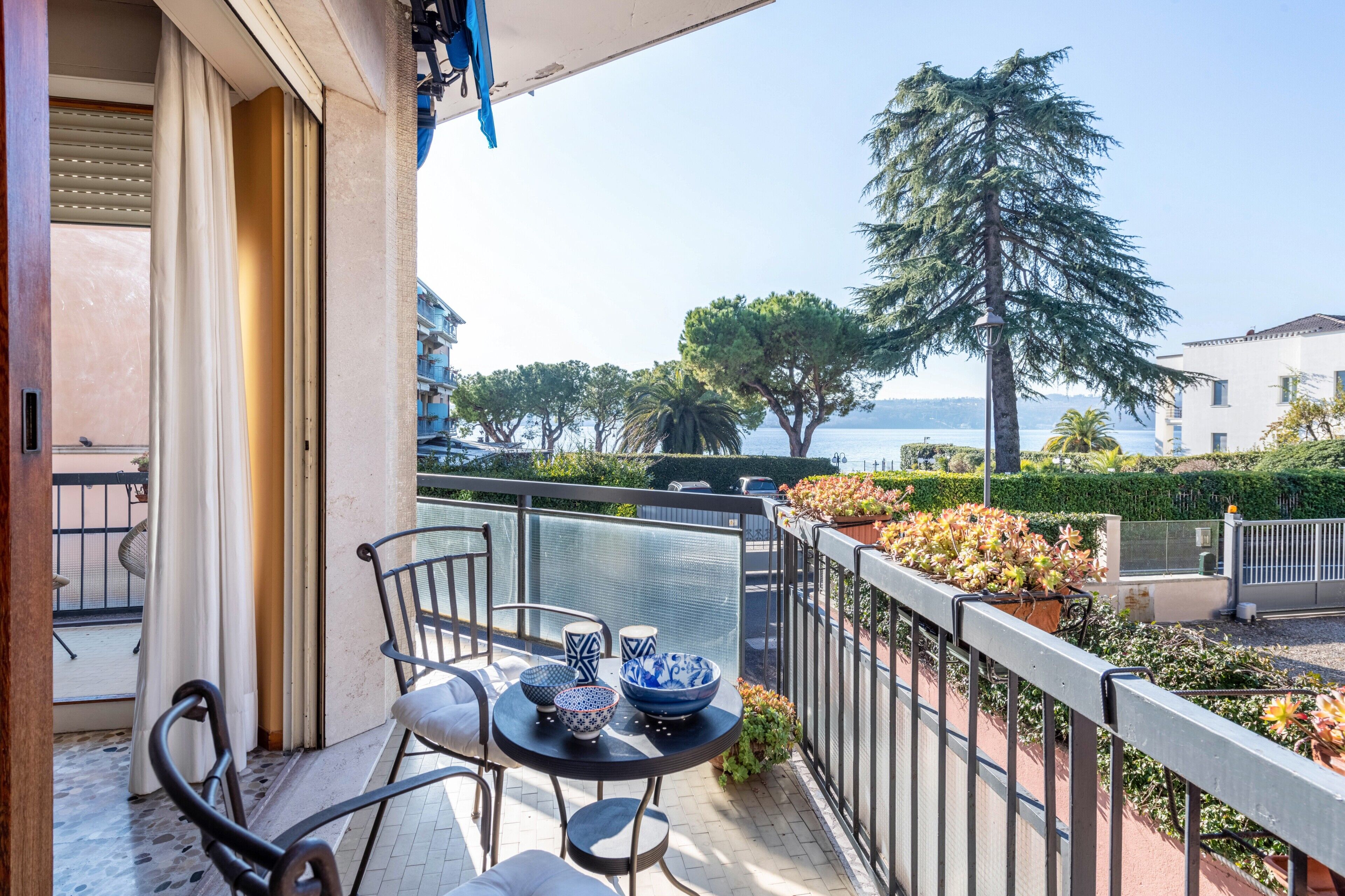 A balcony with a table, chairs, and decorative bowls.