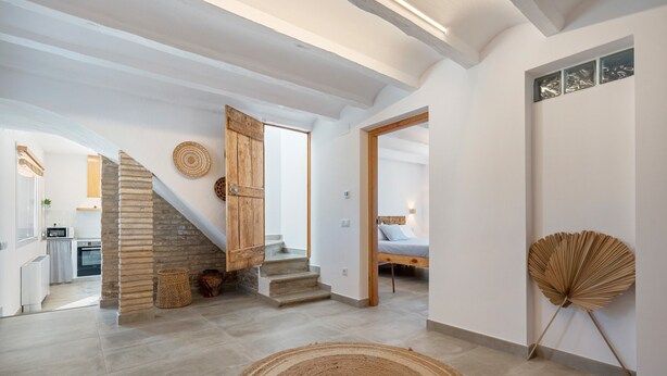 A spacious interior with a staircase, a bed, and a dining area. - Holiday Home 'Mas Midó' with Mountain View, Wi-Fi and Air Conditioning (Sant Jaume d'Enveja)