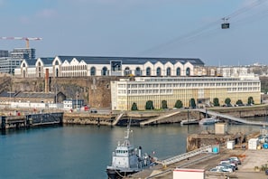 A waterfront building with a dock, a ferry, and a cable car. - Apartment 'Les Capucins - T2 Tout Confort' with Private Terrace, Private Garden and Wi-Fi (Brest)