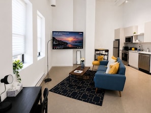 Una sala de estar moderna con un sofá, una mesa de centro y un televisor de pantalla plana.
