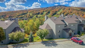 Una zona residencial con casas modernas, cielo despejado y follaje otoñal.