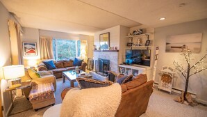 Una sala de estar acogedora con chimenea, asientos cómodos y una televisión.