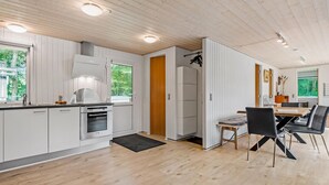 Eine moderne Küche mit weißen Schränken, einem eingebauten Ofen und einem großen Fenster.