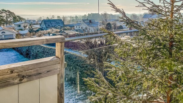 A residential area with houses, a wooden fence, and snow-covered ground.