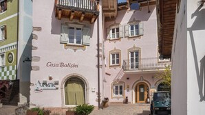 Un bâtiment sur lequel on peut lire l’inscription « Casa Batisci », avec un petit véhicule garé devant.