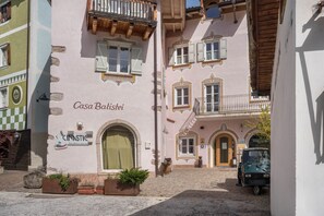 Un bâtiment sur lequel on peut lire l’inscription « Casa Batisci », avec un petit véhicule garé devant.