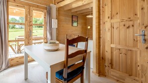 A wooden interior with a white table, a wooden chair, and a picture on the wall.
