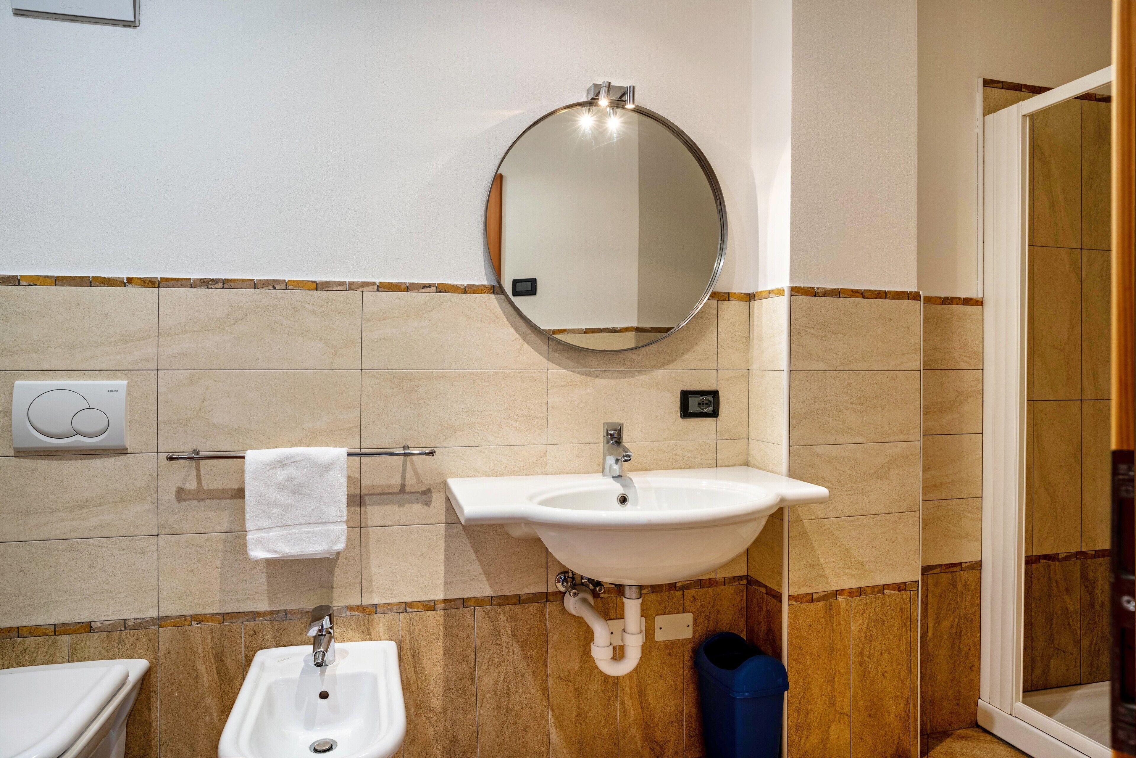 A bathroom with a sink, mirror, and towel rack.