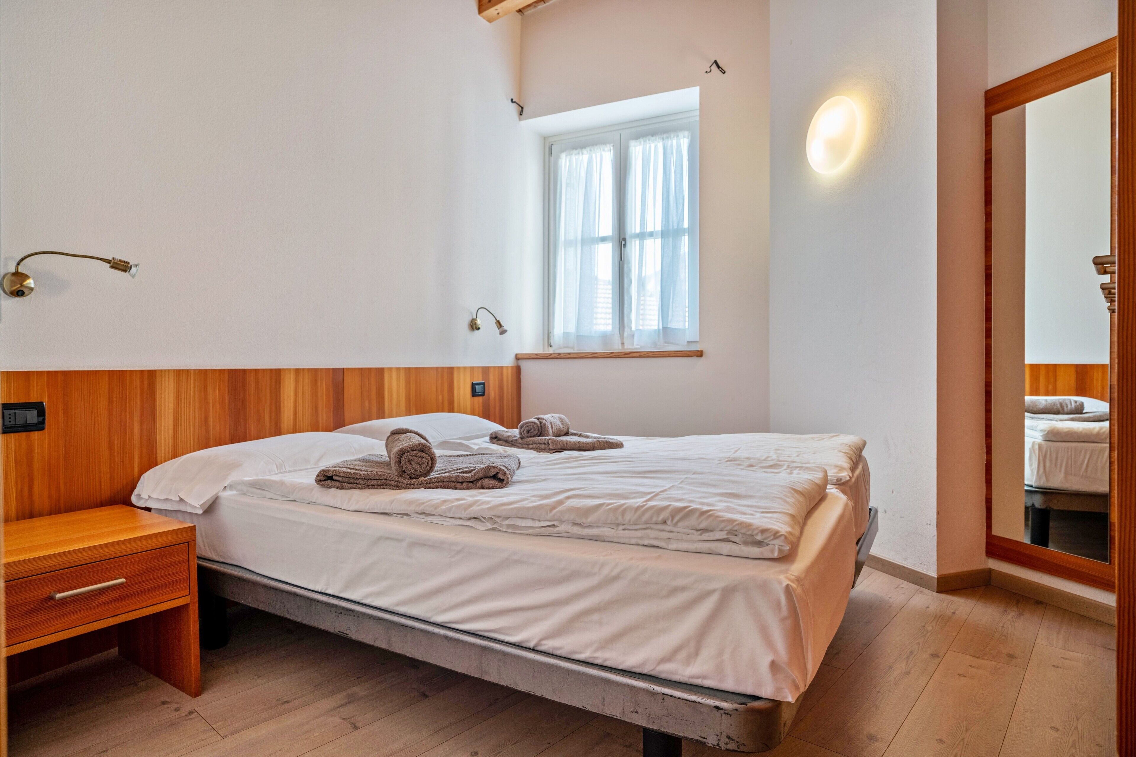 Ein Schlafzimmer mit Bett, Nachttisch und Fenster.