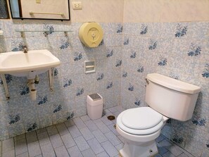 Een douche, handdoeken, zeep, toiletpapier