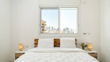 2 dormitorios y tabla de planchar con plancha