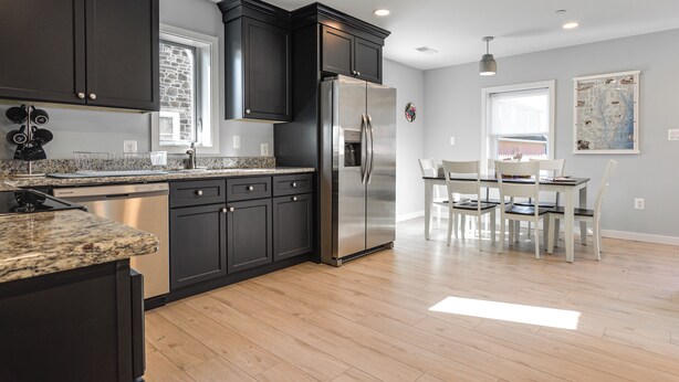 A modern kitchen with dark cabinets, stainless steel appliances, and a granite countertop. - Waterfront Historical District Home Near River (North East)