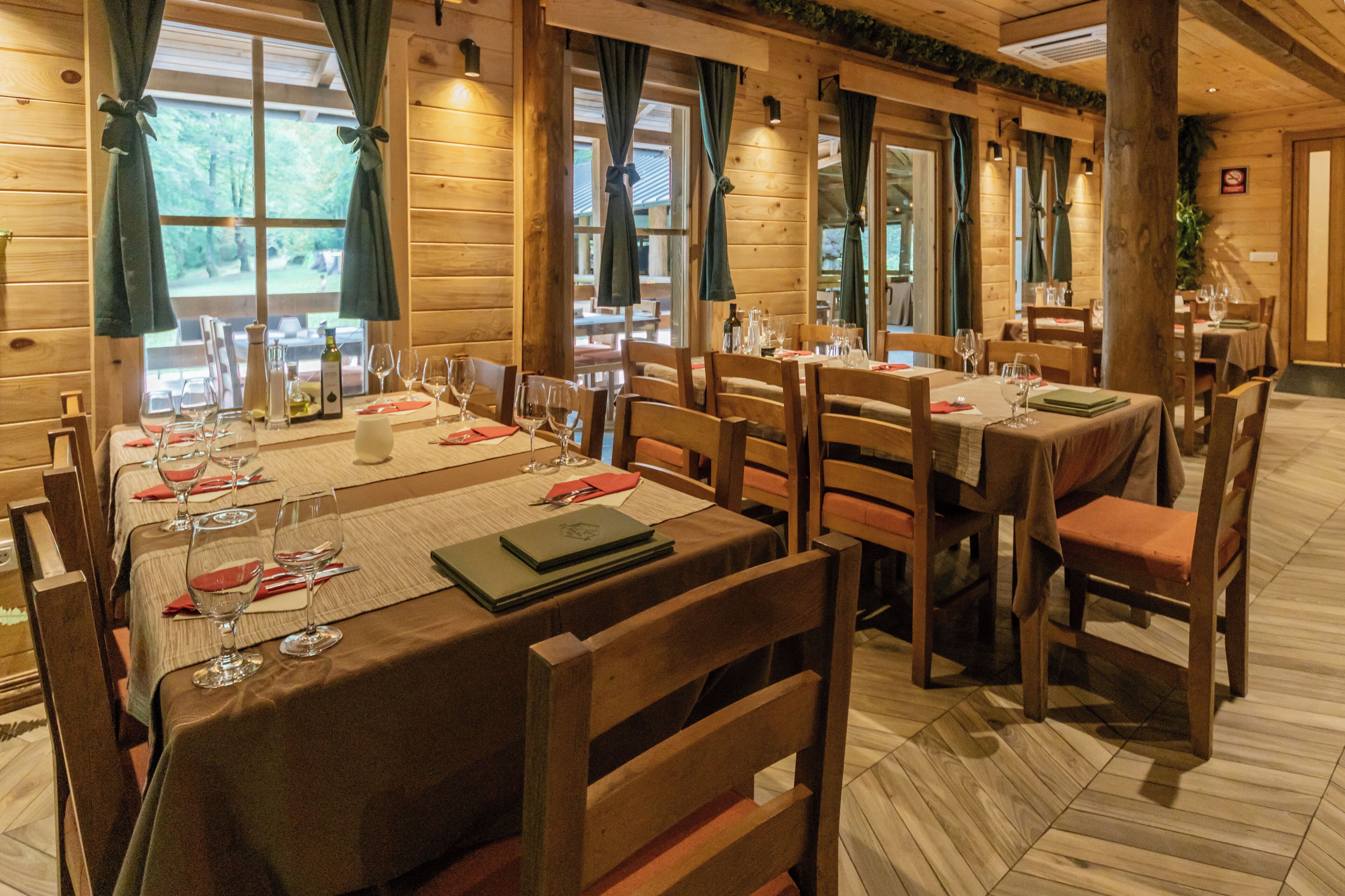 A restaurant with wooden interior and tables set for dining.