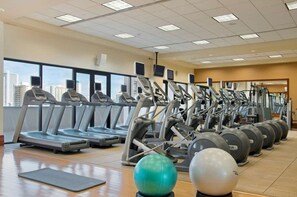 A gym with treadmills, elliptical machines, and exercise balls. - Oahu | Oceanview Coastal Stay | Resort Pool & Beach (Honolulu Oahu)